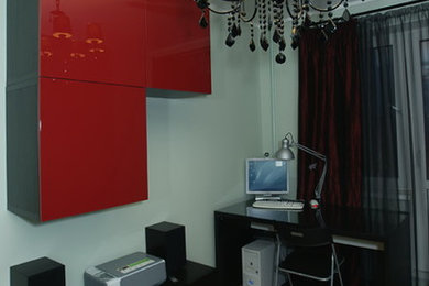 Imagen de despacho ecléctico pequeño con paredes verdes, suelo laminado y escritorio independiente