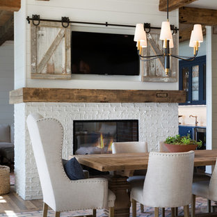 Große Maritime Wohnküche mit weißer Wandfarbe, braunem Holzboden, Tunnelkamin, Kaminsims aus Backstein und braunem Boden in Minneapolis