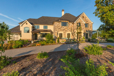 Expansive traditional two-storey beige exterior in Richmond with stone veneer and a gable roof.