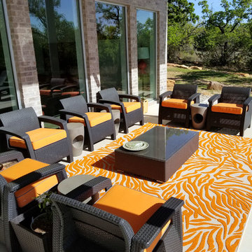 Sunbrella Canvas Tangerine seat cushions pop on luxurious patio