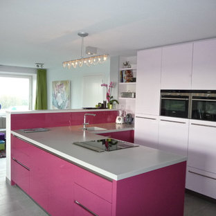 Mittelgroße Moderne Küche in L-Form mit Unterbauwaschbecken, flächenbündigen Schrankfronten, roten Schränken, Quarzit-Arbeitsplatte, Vorratsschrank, Küchenrückwand in Rosa, Elektrogeräten mit Frontblende, Keramikboden und Halbinsel in Amsterdam