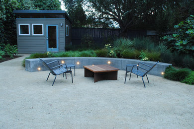 This is an example of a large contemporary backyard xeriscape in San Francisco with a retaining wall and gravel.