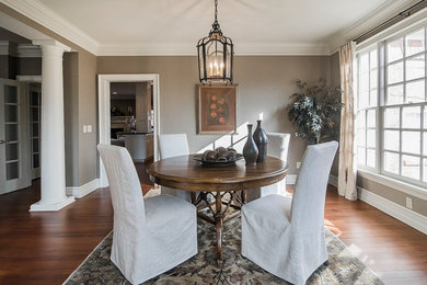 Enclosed dining room - mid-sized transitional dark wood floor and brown floor enclosed dining room idea in Columbus with gray walls and no fireplace
