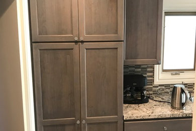 Inspiration for a mid-sized transitional kitchen remodel in San Francisco with an undermount sink, recessed-panel cabinets, dark wood cabinets, granite countertops, multicolored backsplash, glass tile backsplash, stainless steel appliances, no island and multicolored countertops