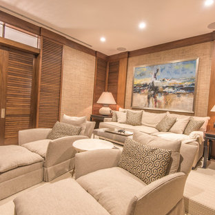Home theater - large tropical enclosed carpeted home theater idea in Tampa with beige walls and a wall-mounted tv