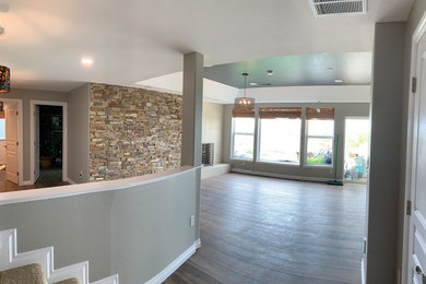 Basement - mid-sized eclectic walk-out vinyl floor basement idea in Denver with gray walls, a standard fireplace and a tile fireplace