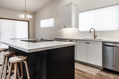 Inspiration for a mid-sized 1960s l-shaped vinyl floor and gray floor open concept kitchen remodel in Other with a single-bowl sink, shaker cabinets, blue cabinets, quartz countertops, white backsplash, subway tile backsplash, stainless steel appliances, an island and white countertops