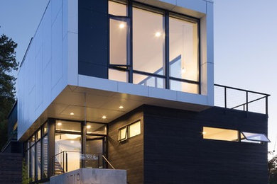 Example of a mid-sized minimalist multicolored three-story wood flat roof design in Seattle