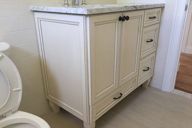 Mid-sized elegant kids' beige tile and ceramic tile bathroom photo in New York with recessed-panel cabinets, white cabinets and granite countertops
