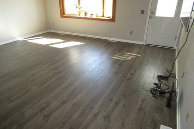 Large transitional enclosed laminate floor and brown floor living room photo in Milwaukee