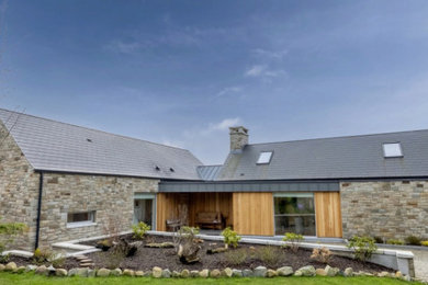 Beach style detached house in Belfast with stone cladding and a pitched roof.