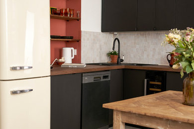 Idées déco pour une cuisine ouverte rétro en L de taille moyenne avec un plan de travail en bois et une crédence beige.