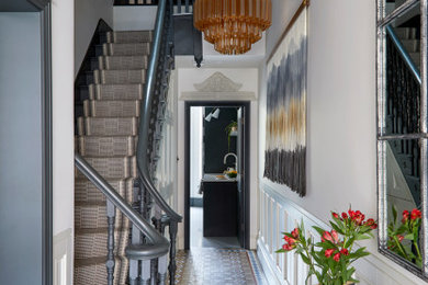 This is an example of a victorian hallway in London with grey walls, multi-coloured floors and wainscoting.