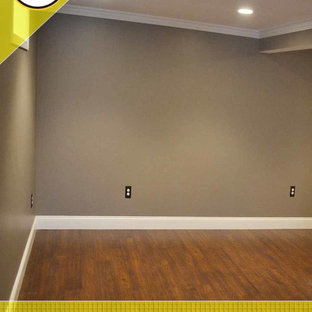 Large classic fully buried basement in Boston with grey walls, dark hardwood flooring and no fireplace.