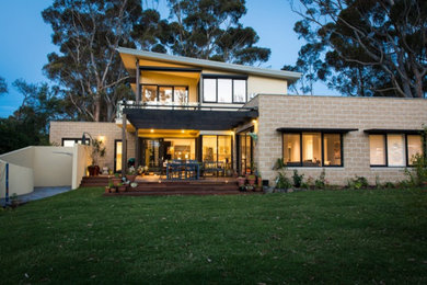 Inspiration for a large contemporary two-storey beige exterior in Melbourne with mixed siding.
