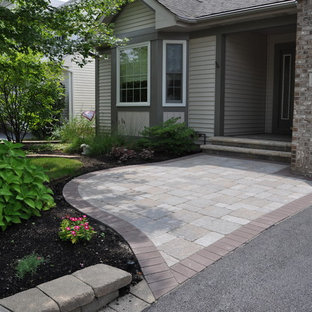 Photo of a small traditional front yard patio in Chicago with brick pavers and a roof extension.