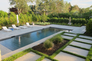 Design ideas for a mid-sized asian backyard rectangular pool in New York with natural stone pavers.
