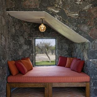 Cette photo montre une chambre méditerranéenne avec un sol en brique et un mur gris.