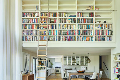Photo of a contemporary open concept family room in New York with a library, white walls, medium hardwood floors and brown floor.
