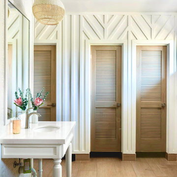 A renovated club restroom — olive board-and-batten in a chevron pattern, louvere