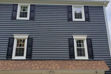 Diseño de fachada de casa azul y marrón minimalista de dos plantas con revestimiento de vinilo y tejado de teja de madera