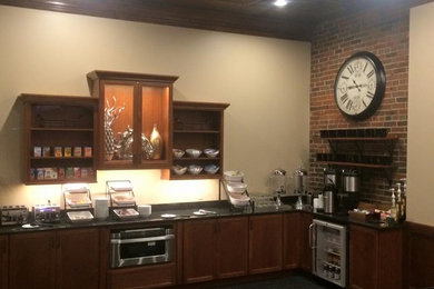 Large transitional u-shaped carpeted home bar photo in Other with recessed-panel cabinets, medium tone wood cabinets and granite countertops