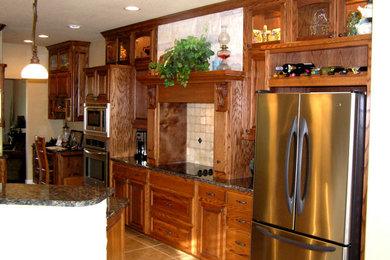 Inspiration for a kitchen remodel in Dallas with raised-panel cabinets, medium tone wood cabinets, stainless steel appliances and two islands