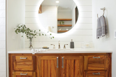 カンザスシティにあるトランジショナルスタイルのおしゃれな浴室 (中間色木目調キャビネット、白い壁、白い洗面カウンター、洗面台1つ、造り付け洗面台) の写真