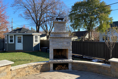 Design ideas for a mid-sized contemporary backyard concrete paver landscaping in Minneapolis with a fireplace.