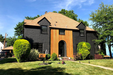 Photo of a mid-sized contemporary two-storey black house exterior in Other with wood siding.