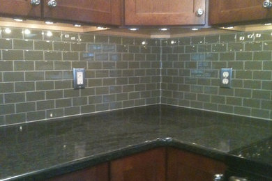 Eat-in kitchen - mid-sized u-shaped eat-in kitchen idea in Other with medium tone wood cabinets, green backsplash, ceramic backsplash and stainless steel appliances