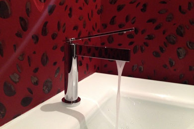 Inspiration for a medium sized contemporary cloakroom in Other with red walls, glass worktops and a built-in sink.
