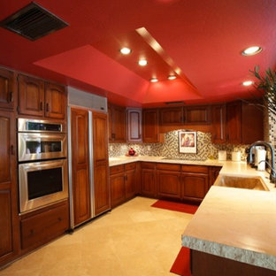 Mid-sized elegant u-shaped travertine floor enclosed kitchen photo in Phoenix with an undermount sink, raised-panel cabinets, dark wood cabinets, limestone countertops, multicolored backsplash, stone tile backsplash, stainless steel appliances and no island