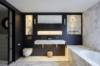 Immagine di una grande stanza da bagno padronale contemporanea con vasca da incasso, WC sospeso, piastrelle blu, lavabo sospeso, top in marmo e due lavabi