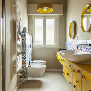 BAGNO in resina giallo con piastrelle artigianali colorate e mobili di recupero