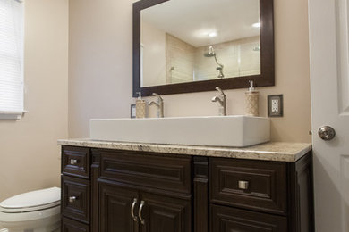 Doorless shower - large modern master beige tile and porcelain tile porcelain tile doorless shower idea in Philadelphia with recessed-panel cabinets, dark wood cabinets, a two-piece toilet, beige walls, a trough sink and granite countertops