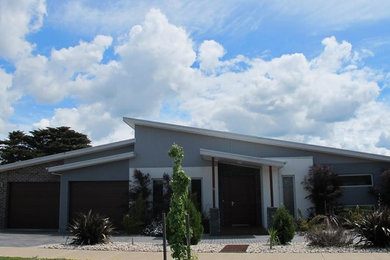 Photo of a contemporary one-storey brick grey exterior in Geelong with a flat roof and a metal roof.