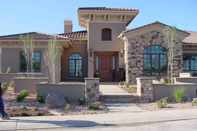 Large mediterranean beige two-story stone house exterior idea in Other with a hip roof and a tile roof