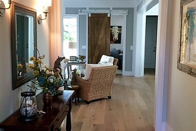 Inspiration for a mid-sized coastal medium tone wood floor and brown floor hallway remodel in Other with beige walls