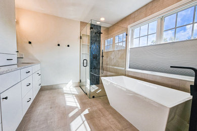 Photo of a contemporary master bathroom in DC Metro with flat-panel cabinets, white cabinets, a freestanding tub, a curbless shower, beige tile, ceramic tile, ceramic floors, an undermount sink, engineered quartz benchtops, beige floor, a hinged shower door, multi-coloured benchtops, an enclosed toilet, a double vanity and a built-in vanity.