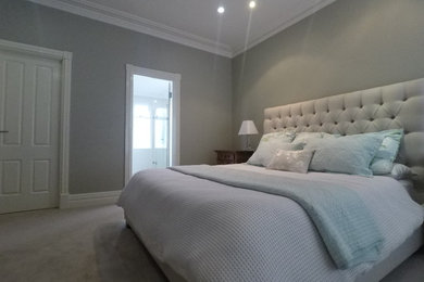 Inspiration for a large traditional master bedroom in Perth with grey walls and carpet.