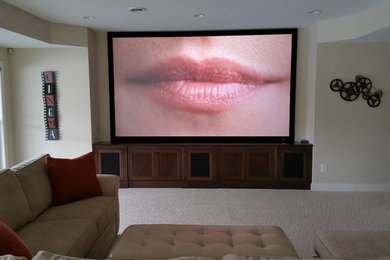 Medium sized traditional open plan home cinema in Cincinnati with beige walls, carpet, a projector screen and beige floors.