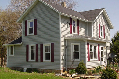 Example of a gray two-story vinyl exterior home design in Other