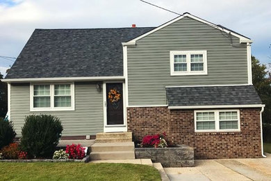 Mid-sized contemporary green split-level vinyl house exterior idea in Philadelphia with a clipped gable roof and a shingle roof