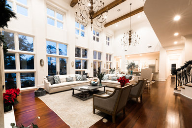 Inspiration for a large transitional open concept dark wood floor family room remodel in New Orleans with white walls and a standard fireplace