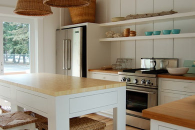 Large trendy light wood floor kitchen photo in San Francisco with stainless steel appliances, wood countertops, shaker cabinets, white cabinets and an island