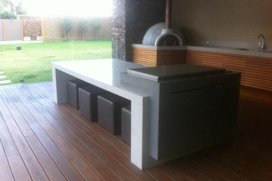 Photo of a large contemporary backyard patio in Melbourne with an outdoor kitchen and a roof extension.