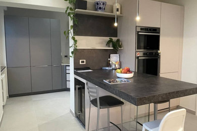 Foto di una cucina minimalista chiusa e di medie dimensioni con ante lisce, penisola e top bianco