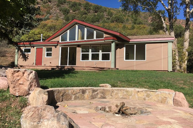 Small minimalist multicolored one-story concrete fiberboard house exterior photo in Denver with a mixed material roof and a hip roof