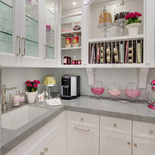 Свежая идея для дизайна: большая п-образная кухня в стиле современная классика с кладовкой, одинарной раковиной, фасадами в стиле шейкер, белыми фасадами, столешницей из кварцевого композита, белым фартуком, фартуком из стеклянной плитки, техникой под мебельный фасад и полом из известняка без острова - отличное фото интерьера